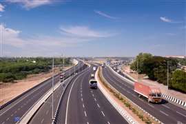 Newly built highway in India set against a blue sky, carring light traffic.