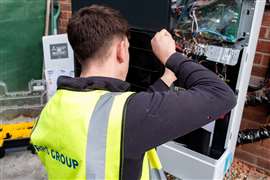 An installer works on retrofitting a heat pump to a residential property